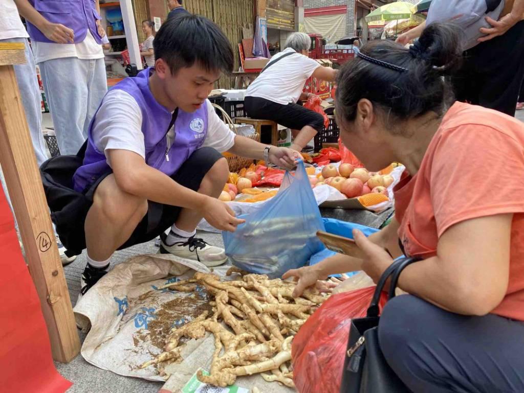 图为实践团成员帮助当地农民售卖生姜。通讯员黄舒婷供图