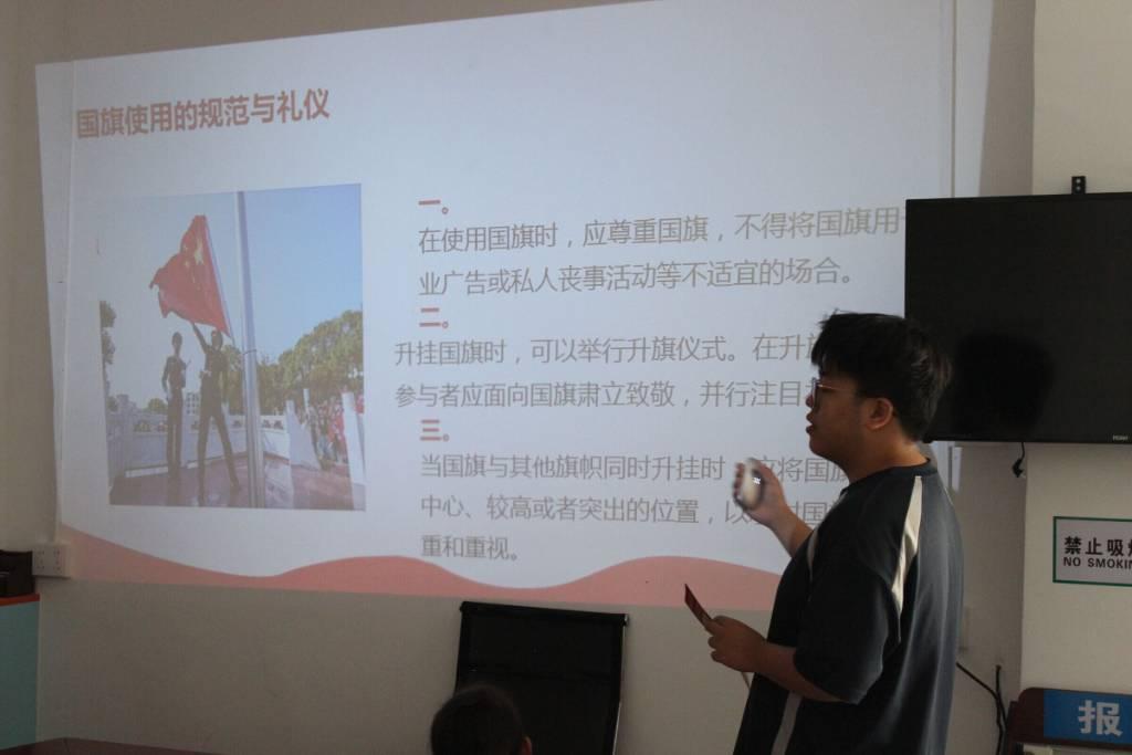 图为服务队成员为当地社区学生讲解国旗使用的规范与礼仪