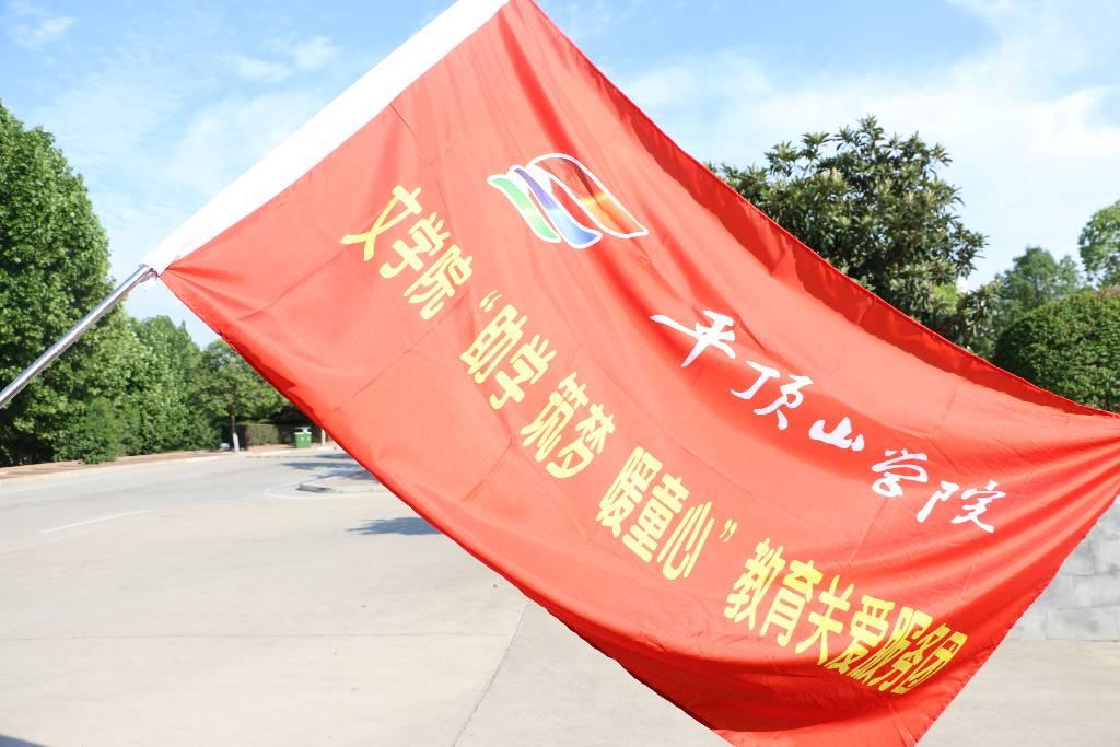 图为文学院“助学 筑梦 暖童心”教育关爱服务团出征旗帜 通讯员 李双印摄