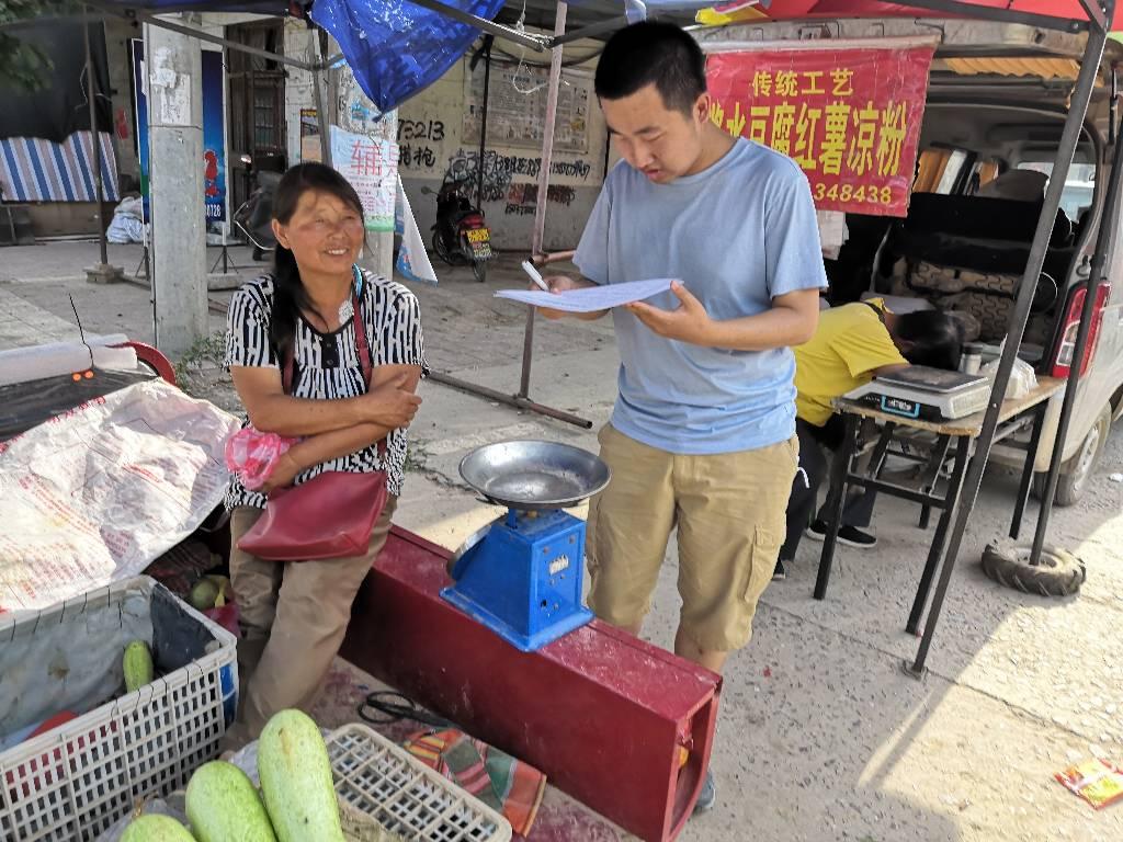 图为“三下乡”实践团成员在采访街边摊主