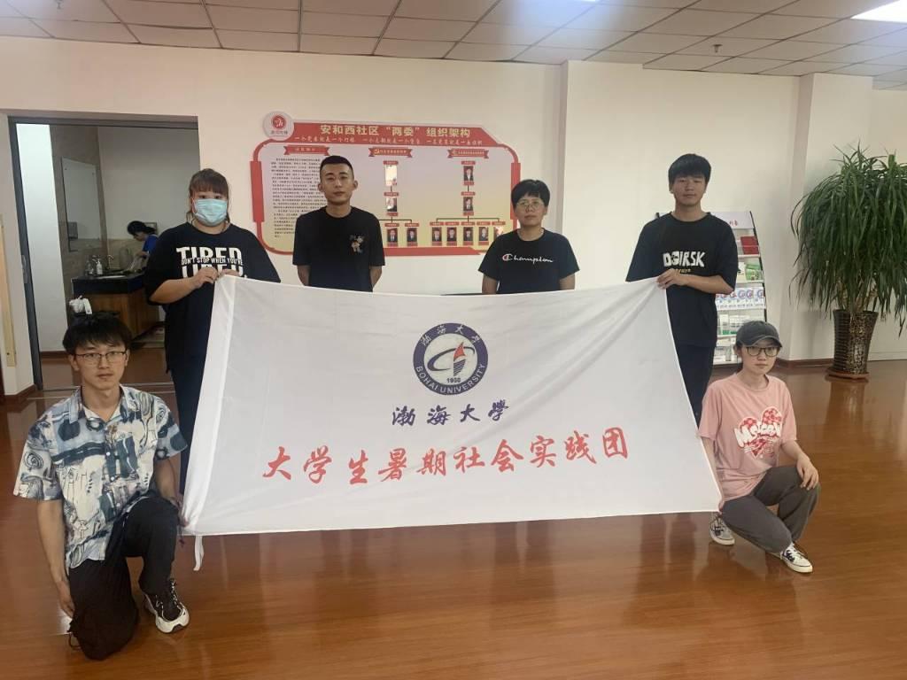 01图为队员与凌河区龙江街道安和西社区书记探讨基层在优化营商环境中的作用