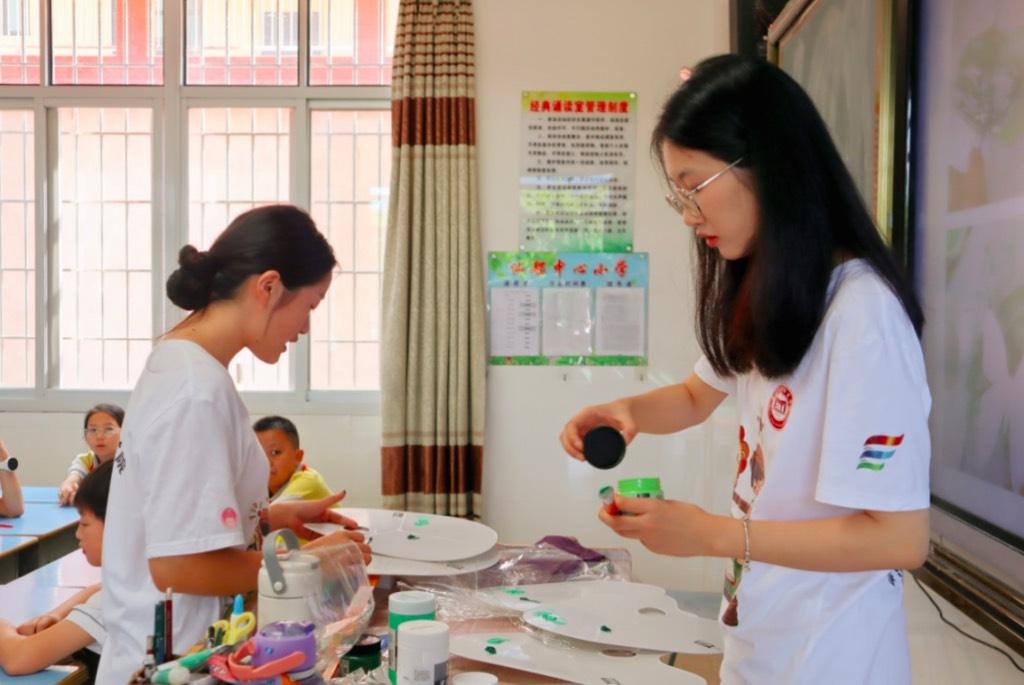 图为实践队队员在调色板上调制绿色。集美大学“青春沃土”实践队队员 沈景仪 供图